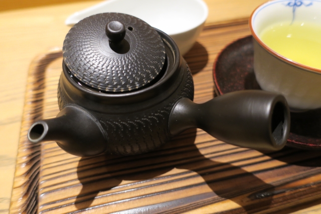 茶葉を入れてお茶を注ぐ、取っ手の付いた黒い急須（きゅうす）